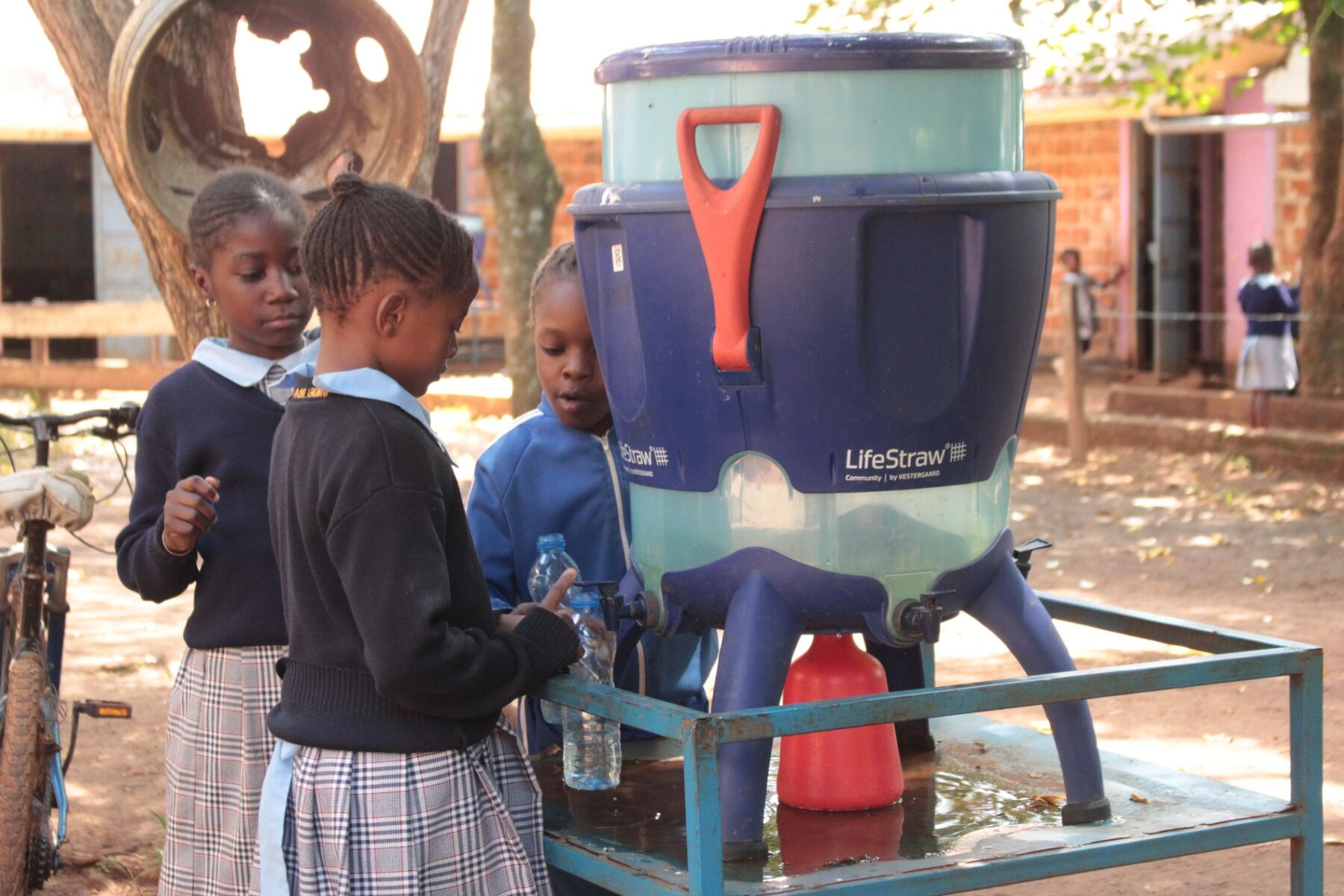 Pupils filling water bottles at a LifeStraw filter station