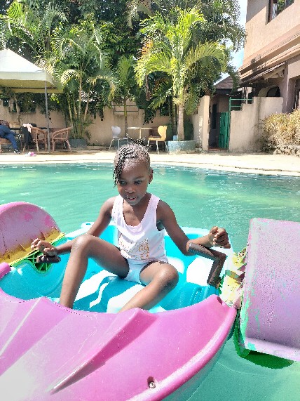 A pupil pedalling a colourful boat at a school trip