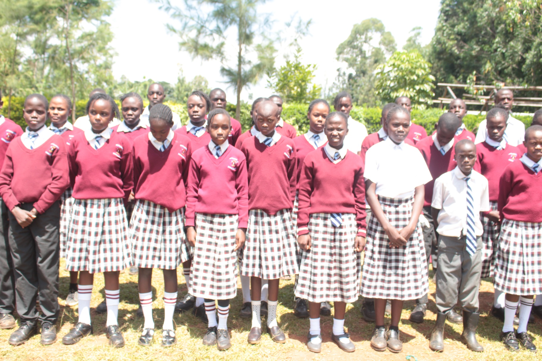 Primary pupils lined up in their maroon and checked uniforms