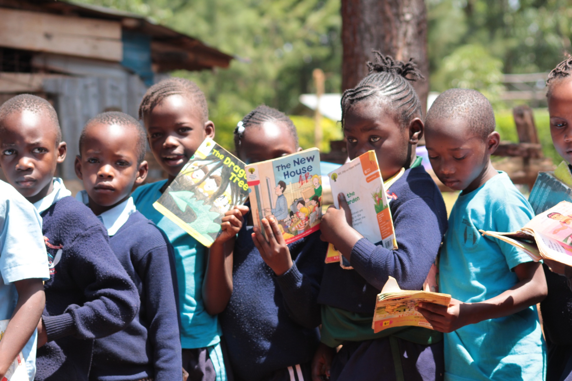 Young learners showing their reading books to the camera